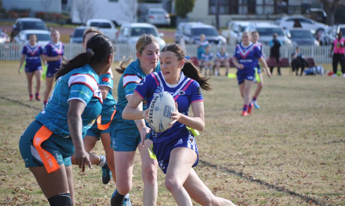 Molong Bulls fullback Katie Fulwood attempts to evade Orange United Warriors defedners. Picture by Dominic Unwin