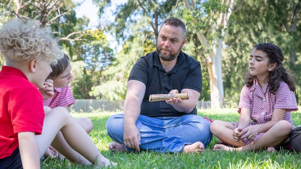 Wiradjuri educator Adam Shipp holds a talking stick as part of a yarning circle in a school. Picture supplied