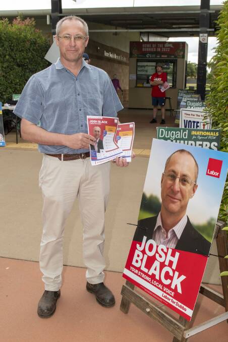 Dubbo candidate Josh Black hands out 'how to vote' cards at the APEX Oval pre-poll site in Dubbo. Picture by Belinda Soole