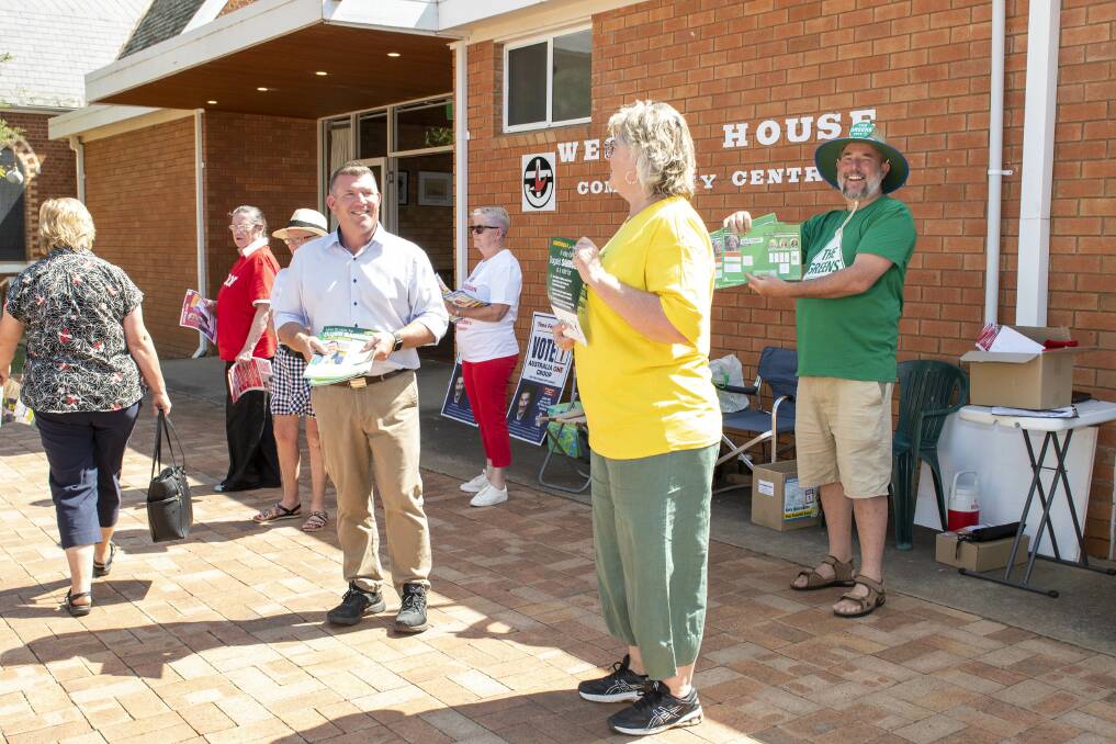 Candidates and their supporters hand out 'how to vote' cards outside the pre-poll booths at the Wesley House Community Centre in Dubbo. Picture by Belinda Soole