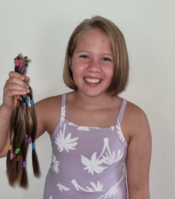 Izabelle Kelly with the hair she cut off to be made into wigs for kids with cancer. Picture supplied.