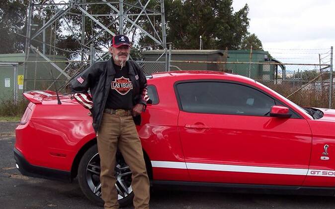Robert Dickie with his prized car, a late model red Mustang Shelby. Photo via NSW Police