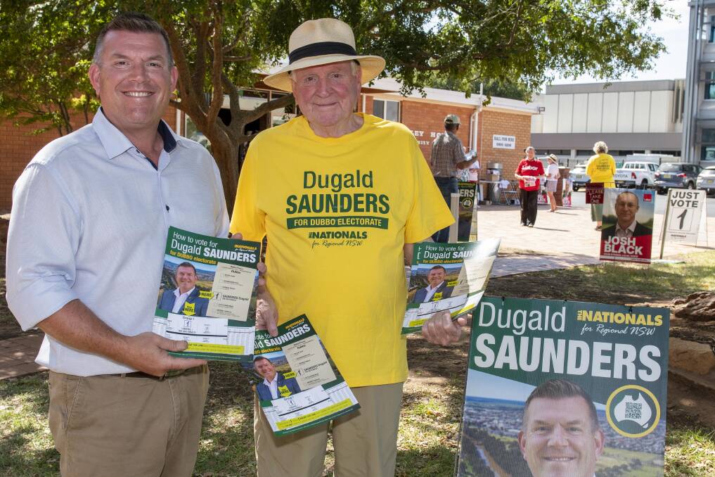 Nationals candidate for Dubbo Dugald Saunders hands out 'how to vote' cards with father Ian Saunders at the Dubbo Uniting Church pre-poll site. Picture by Belinda Soole
