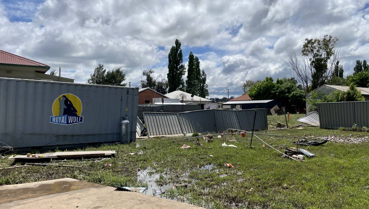 The Bennett's backyard in Molong at their Gidley Street home on November 15, less than 24-hours after flooding, with a shipping container that had tore through the yards from another street. Picture by Emily Gobourg.