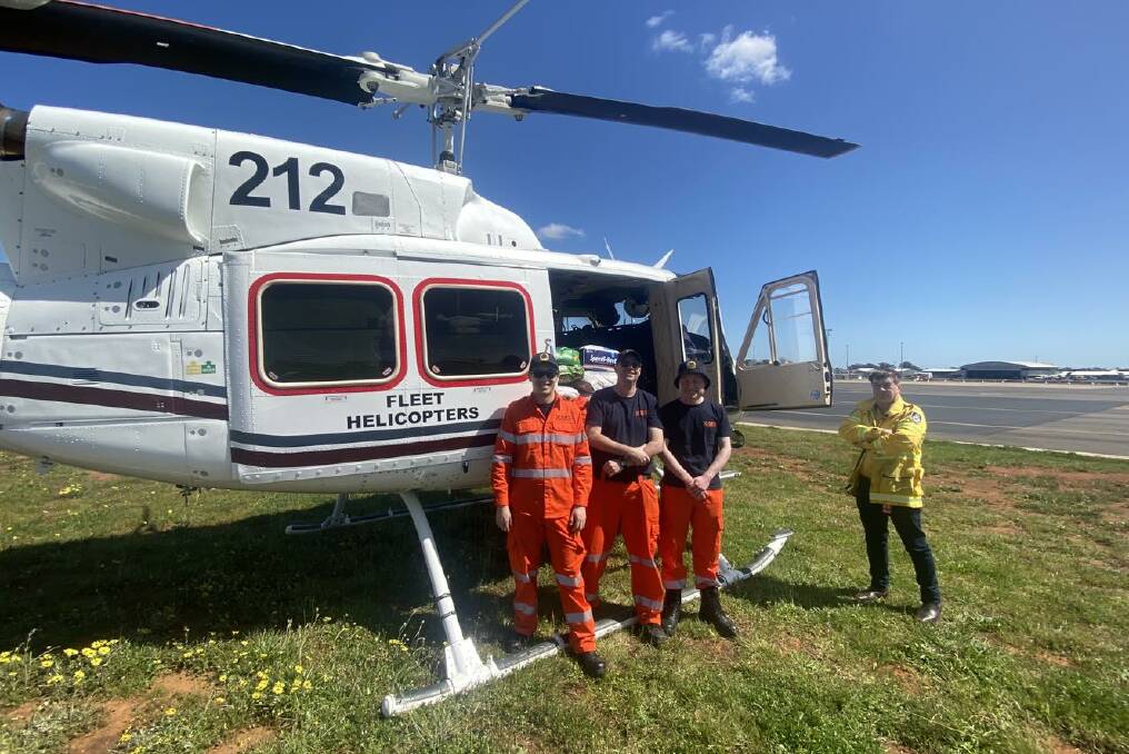 A re-supply team of the NSW State Emergency Service western zone using a helicopter to drop off groceries, medicine, and water. Picture Supplied