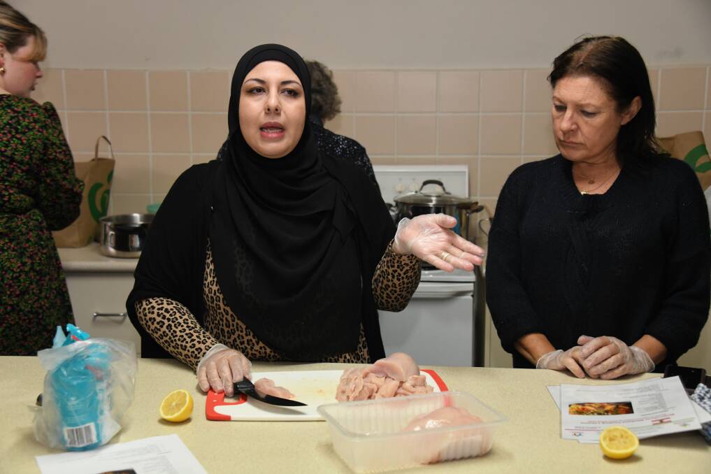 Salam Farachi Taleb shows her cooking class learners how meats are chopped and infused with seven Lebanese spices before they go into the pan. Picture by Amy McIntyre