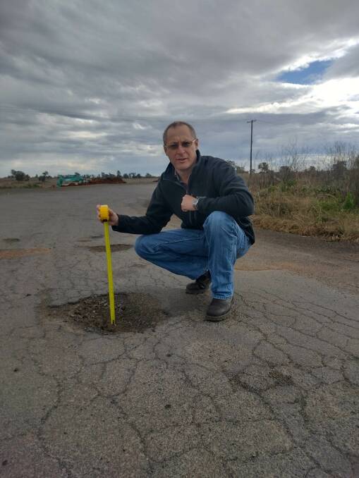 Labor candidate Josh Black stands with a pothole in the region. Picture supplied 