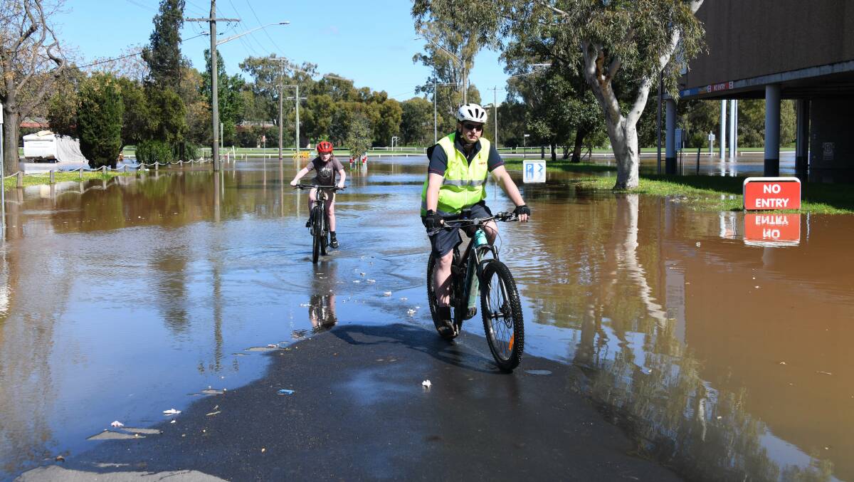 Residents came out to see the flood waters, some even tried their luck riding their bike through the water. Picture by AMY MCINTYRE 