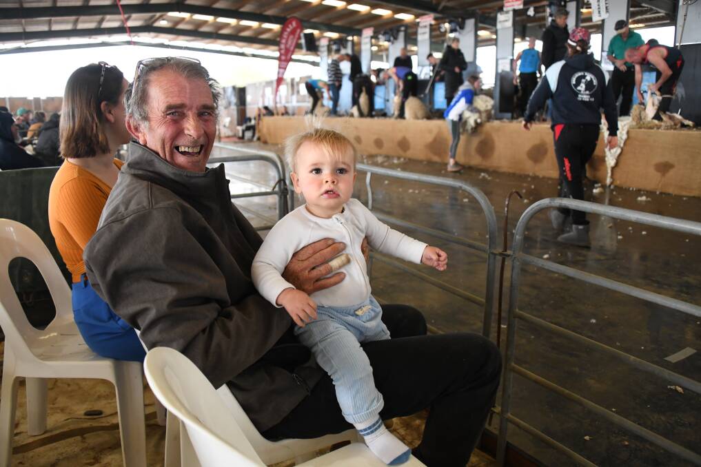 Jim Murray with baby Mark Murray watching Dad, Andrew Murray shearing. Picture by Amy McIntyre 