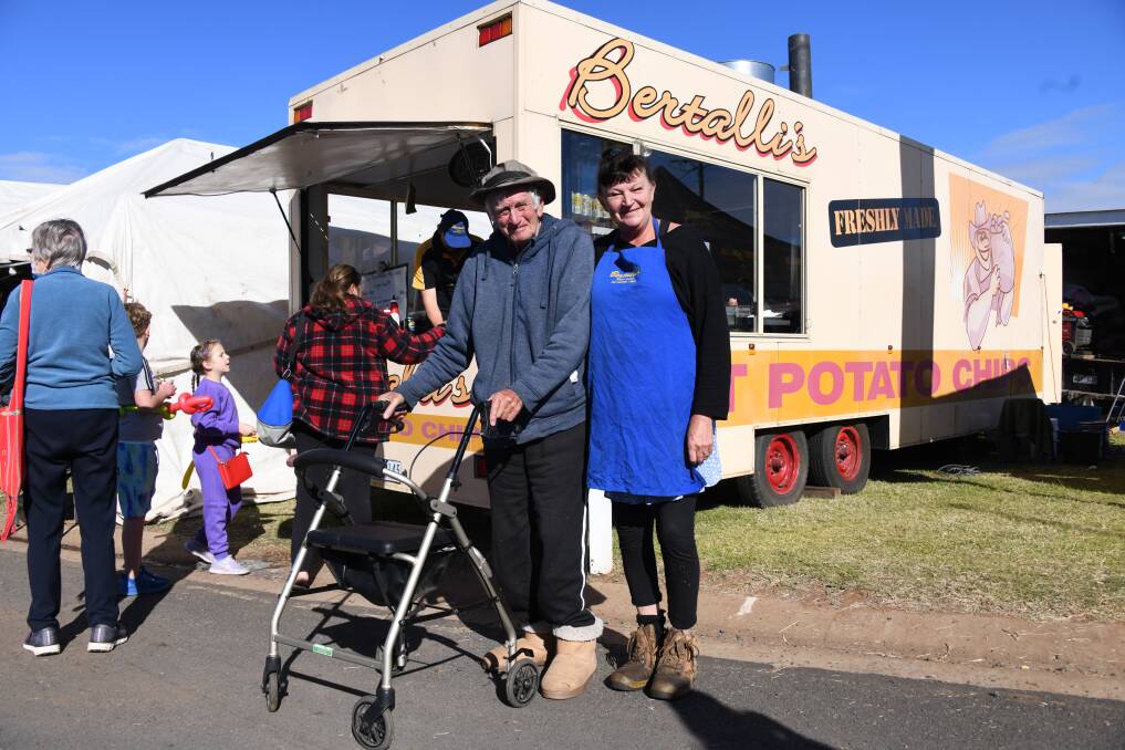 Terry Bertalli and his daughter Pam in front of the Bertalli's Hot Potato Chip van with a line of customers behind them. Picture by Amy McIntyre 