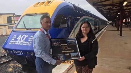 Courtney Triplett (right) on Dubbo station with a collage she made for the XPT train's 40th birthday. Picture supplied