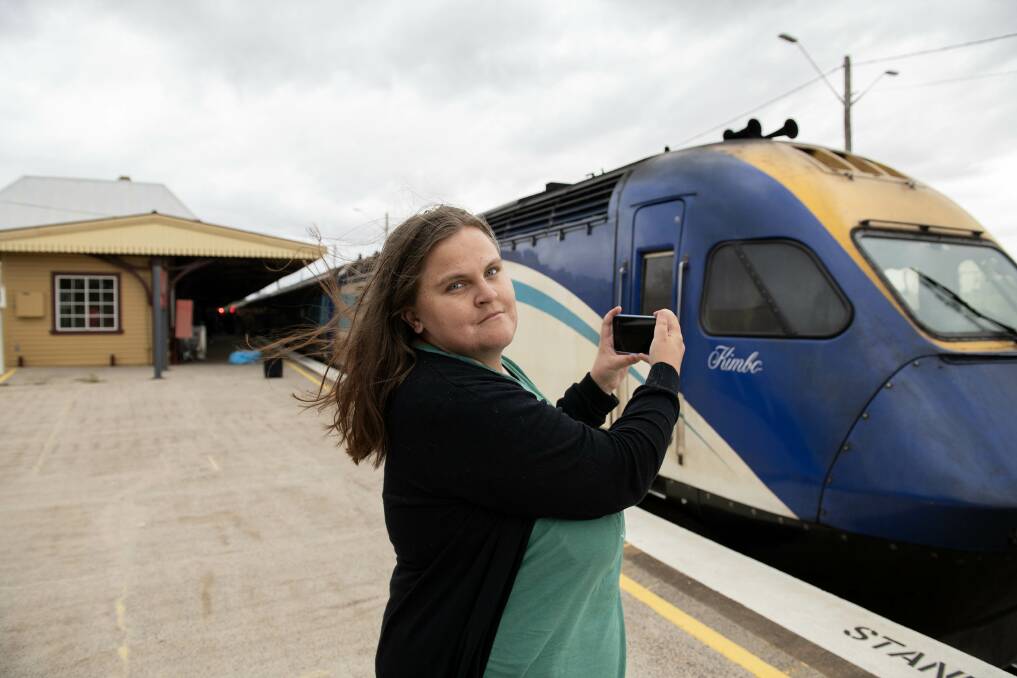 Courtney Triplett holds her phone ready to take a picture of a train at Dubbo station. Picture by Belinda Soole