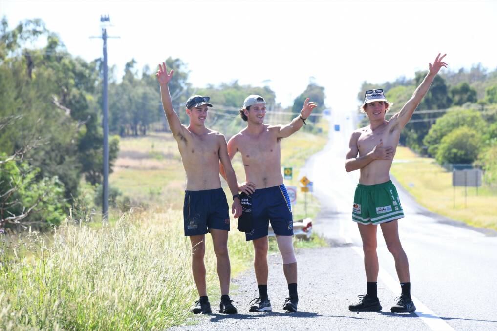Dubbo boys Matt Bridges, Cameron Longhurst and Connor Etcell pictured waving to a honking car while making their way down the Golden Highway into Dubbo to raise money for the Black Dog Foundation. Picture by Amy McIntyre