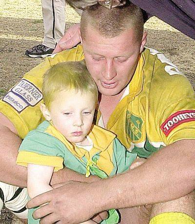 FRIEND TO FOE: Former CYMS captain-coach Ryan Prevett, pictured with son Jai after the 2002 grand final, will play for Riverina on Saturday.